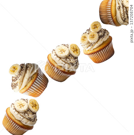 Banana cupcakes topped with cream frosting, banana slices, and chia seeds, isolated on a white background 137208704