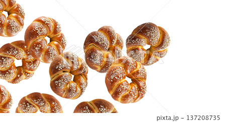 Multiple twisted pretzel buns or bagel with coarse salt topping arranged in seamless pattern isolated on white background 137208735