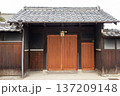 日本の伝統的な建築様式を持つ古民家の門に取り付けられたしめ縄 137209148