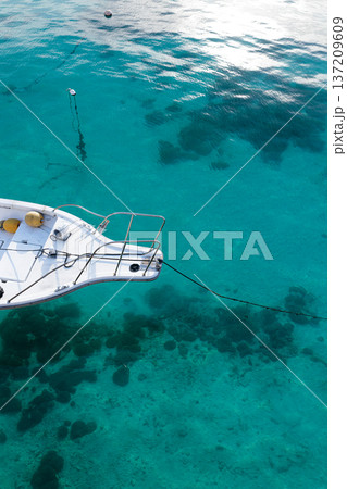 沖縄の透明な海に係留されたボートとサンゴ礁｜南国の海風景 137209609