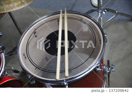 Drumsticks resting on a snare drum in a music studio during a practice session Drumsticks resting on a snare drum in a music studio during a practice session 137209642