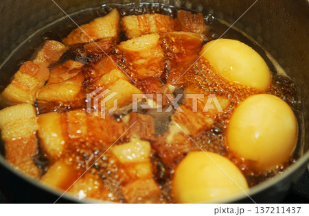 鍋で煮込んでいる豚の角煮と煮卵 137211437