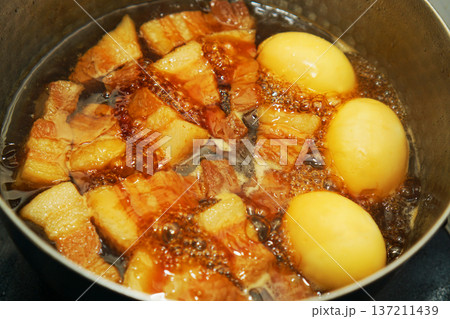 鍋で煮込んでいる豚の角煮と煮卵 鍋で煮込んでいる豚の角煮と煮卵 137211439