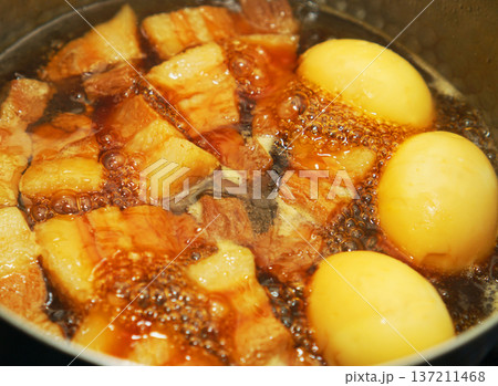 鍋で煮込んでいる豚の角煮と煮卵 鍋で煮込んでいる豚の角煮と煮卵 137211468