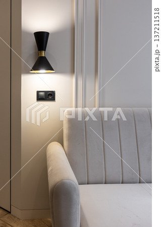 Black wall sconce lighting beside modern sofa Black wall sconce lighting beside modern sofa 137211518