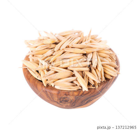 Unpeeled oat grains isolated on white background. Organic dry oat seeds in wooden bowl. Clipping path. 137212965