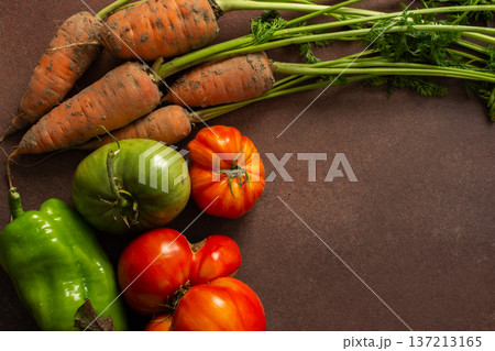 A group of fresh vegetables is placed in a circle on a wooden table. There are carrots, tomatoes, and beets. The colors are bright, indicating freshness and quality A group of fresh vegetables is placed in a circle on a wooden table. There are carrots, tomatoes, and beets. The colors are bright, indicating freshness and quality 137213165