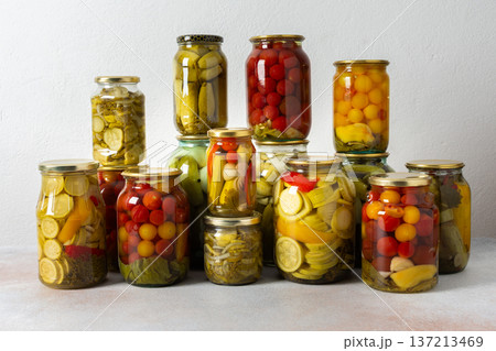 Canning is a common activity in the kitchen as jars filled with vegetables and fruits line the counter. This practice helps in preserving food for winter use and has a long tradition 137213469