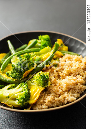 Quinoa bowl features boiled eggs, green beans, and broccoli. A fresh salad sits nearby. A cup of coffee completes the healthy breakfast setting Quinoa bowl features boiled eggs, green beans, and broccoli. A fresh salad sits nearby. A cup of coffee completes the healthy breakfast setting 137213503