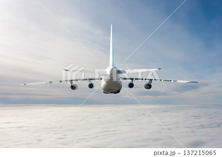 Rear view of the big transport airplane flies in the air above the clouds Rear view of the big transport airplane flies in the air above the clouds 137215065