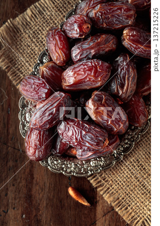 Dried dates fruit in silver tray on a wooden table. 137215226