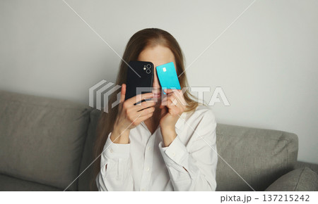 Upset young woman with smartphone, credit bank card, internet fraud, problems with online payments Upset young woman with smartphone, credit bank card, internet fraud, problems with online payments 137215242