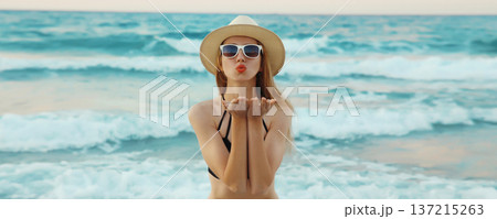 Summer vacation, beautiful young woman blowing kiss in swimsuit, sunglasses, on the beach on sea Summer vacation, beautiful young woman blowing kiss in swimsuit, sunglasses, on the beach on sea 137215263
