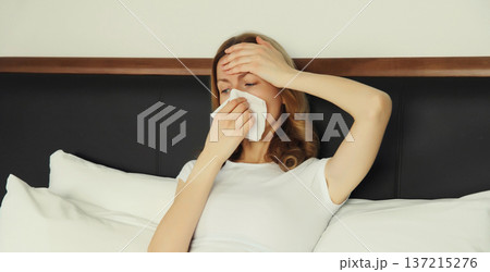 Sick exhausted young woman sneezing blow nose using tissue, unhealthy suffering girl feels unwell 137215276
