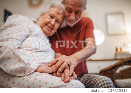 Elderly spouses sharing quiet moment before sleep. Elderly spouses sharing quiet moment before sleep. 137215515