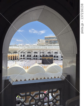 View of the Kaaba and pilgrims at Masjid al-Haram in Mecca framed by an arched window View of the Kaaba and pilgrims at Masjid al-Haram in Mecca framed by an arched window 137216138