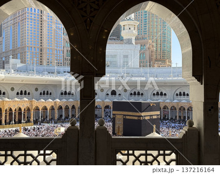 Pilgrims circling the Kaaba at Masjid al-Haram in Mecca framed by ornate mosque arches during Hajj 137216164