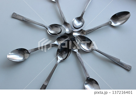 Tablespoons And Teaspoons From One Cutlery Set Laid Out In Form Of Star Concept Photo For Design Or Backgrounds 137216401