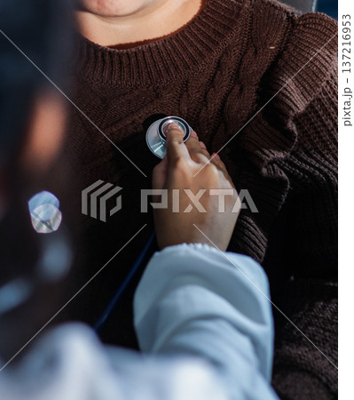 A physician uses a stethoscope to examine a patient's heart during a clinic appointment. A physician uses a stethoscope to examine a patient's heart during a clinic appointment. 137216953
