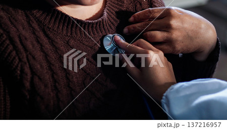 A physician uses a stethoscope to examine a patient's heart during a clinic appointment. A physician uses a stethoscope to examine a patient's heart during a clinic appointment. 137216957
