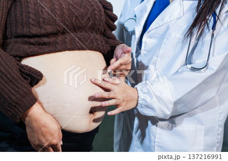 cropped shot of doctor examining pregnant woman during medical consultation cropped shot of doctor examining pregnant woman during medical consultation 137216991