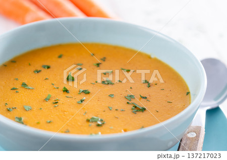 Creamy carrot soup in blue bowl 137217023