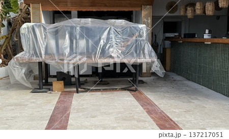 Outdoor bar covered in plastic, closed for maintenance or during off-season, tropical setting 137217051