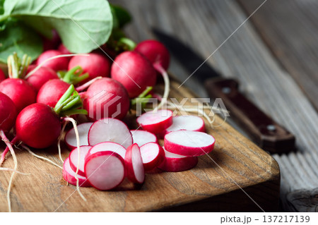 Sliced radishes with whole bunch on cutting board Sliced radishes with whole bunch on cutting board 137217139
