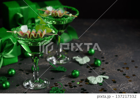Green Cocktails with Rainbow Candy, shamrocks, Gifts and Confetti. Festive St. Patricks Day Celebration Still Life Green Cocktails with Rainbow Candy, shamrocks, Gifts and Confetti. Festive St. Patricks Day Celebration Still Life 137217332