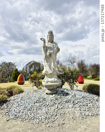 Stone statue of a deity in a sunny park during the Easter holidays in spring. The concept of religious diversity and tolerance. Stone statue of a deity in a sunny park during the Easter holidays in spring. The concept of religious diversity and tolerance. 137217488
