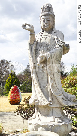 Stone statue of a deity in a sunny park during the Easter holidays in spring. The concept of religious diversity and tolerance. Stone statue of a deity in a sunny park during the Easter holidays in spring. The concept of religious diversity and tolerance. 137217502