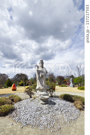 Stone statue of a deity in a sunny park during the Easter holidays in spring. The concept of religious diversity and tolerance. 137217503