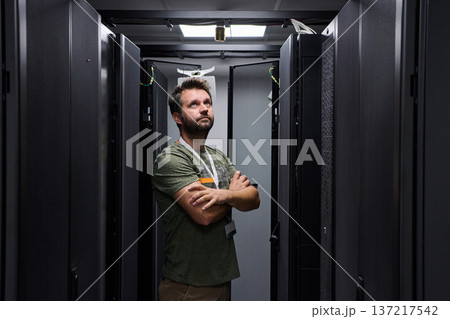 IT technician inspecting servers in a data center server room with racks and network equipment 137217542