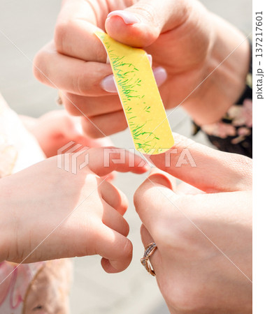 Child wound treatment. Toddler finger protected by caregiver. Parenting responsibility concept. Child wound treatment. Toddler finger protected by caregiver. Parenting responsibility concept. 137217601