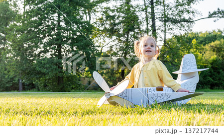 Airplane costume. Toddler imagination flying. Girl outdoor yellow grass fun. 137217744