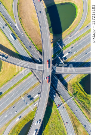Aerial view of a multilevel highway interchange with busy car traffic. Vertical photo. 137218103