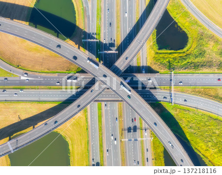 Aerial view of a multilevel highway interchange with busy car traffic. 137218116