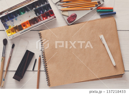 Artist working space background. Watercolor paints and blank craft paper on white wooden desk, top view, flat lay, copy space 137218433