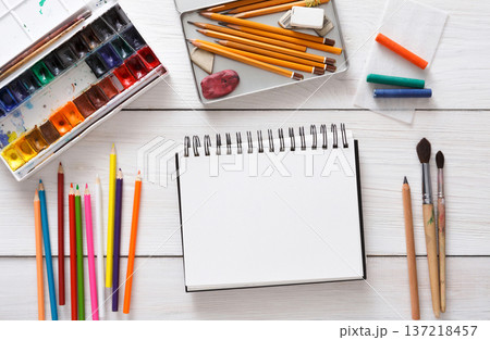 Workplace of artist with copy space. Paints, sketchbook and brushes on white desk, top view, flat lay, objects Workplace of artist with copy space. Paints, sketchbook and brushes on white desk, top view, flat lay, objects 137218457