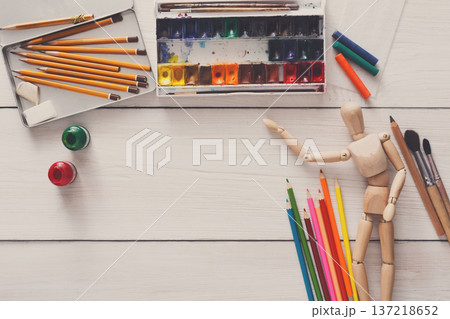 Painting visual art background. Paints and wooden painter man with brushes on white desk, top view, flat lay, objects 137218652
