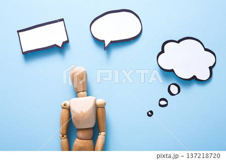 Handcrafted wooden man figure mannequin model dummy doll with blank speech bubble on blue background,objects, nobody Handcrafted wooden man figure mannequin model dummy doll with blank speech bubble on blue background,objects, nobody 137218720