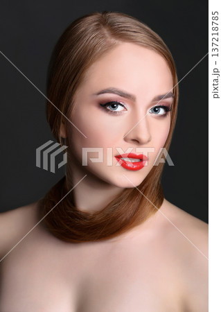 Beauty model on black background, fashion shooting. Woman with makeup, perfect skin and hair posing to camera at studio Beauty model on black background, fashion shooting. Woman with makeup, perfect skin and hair posing to camera at studio 137218785