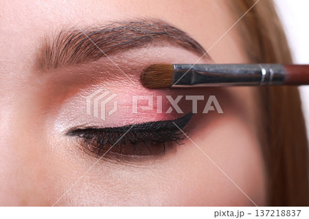 Eyeshadow applying, makeup for eyes closeup. Female model face with fashion make-up, beauty concept isolated Eyeshadow applying, makeup for eyes closeup. Female model face with fashion make-up, beauty concept isolated 137218837