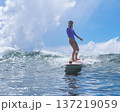 Relaxed Young Woman Enjoying Calm Ride Over Gentle Ocean Wave Beneath Sunny Sky 137219059