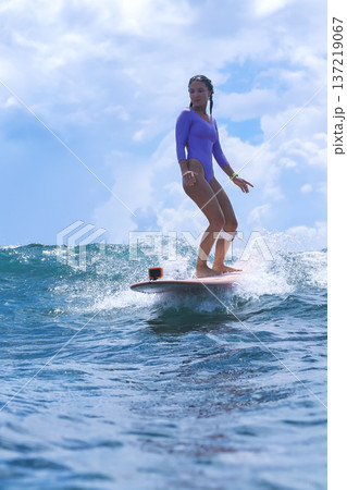 Energetic Young Woman Skillfully Balances On Foam Board Energetic Young Woman Skillfully Balances On Foam Board 137219067