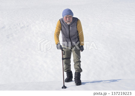 雪上で杖を使ってリハビリをしている老人 雪上で杖を使ってリハビリをしている老人 137219223