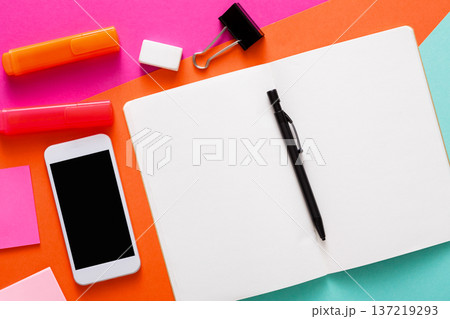A vibrant workspace features a blank notebook, colorful markers, sticky notes, a smartphone, and a pen, creating an inviting atmosphere for writing or brainstorming ideas. A vibrant workspace features a blank notebook, colorful markers, sticky notes, a smartphone, and a pen, creating an inviting atmosphere for writing or brainstorming ideas. 137219293