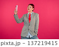 Young adult taking selfie with pink smartphone 137219415