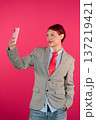 Diverse person taking a selfie with pink smartphone 137219421