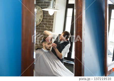 Men barbershop. Making modern hairstyle in male hair salon Men barbershop. Making modern hairstyle in male hair salon 137219510